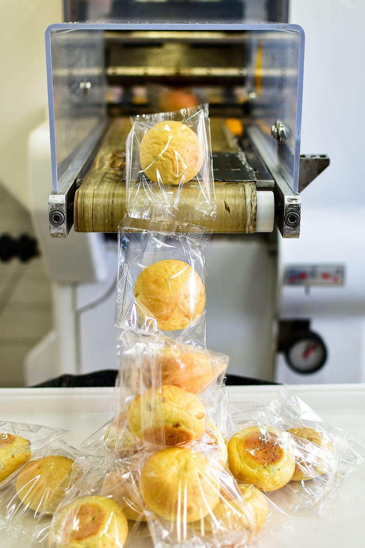 Small round buns are Packed in transparent plastic packaging. Bread production and packaging